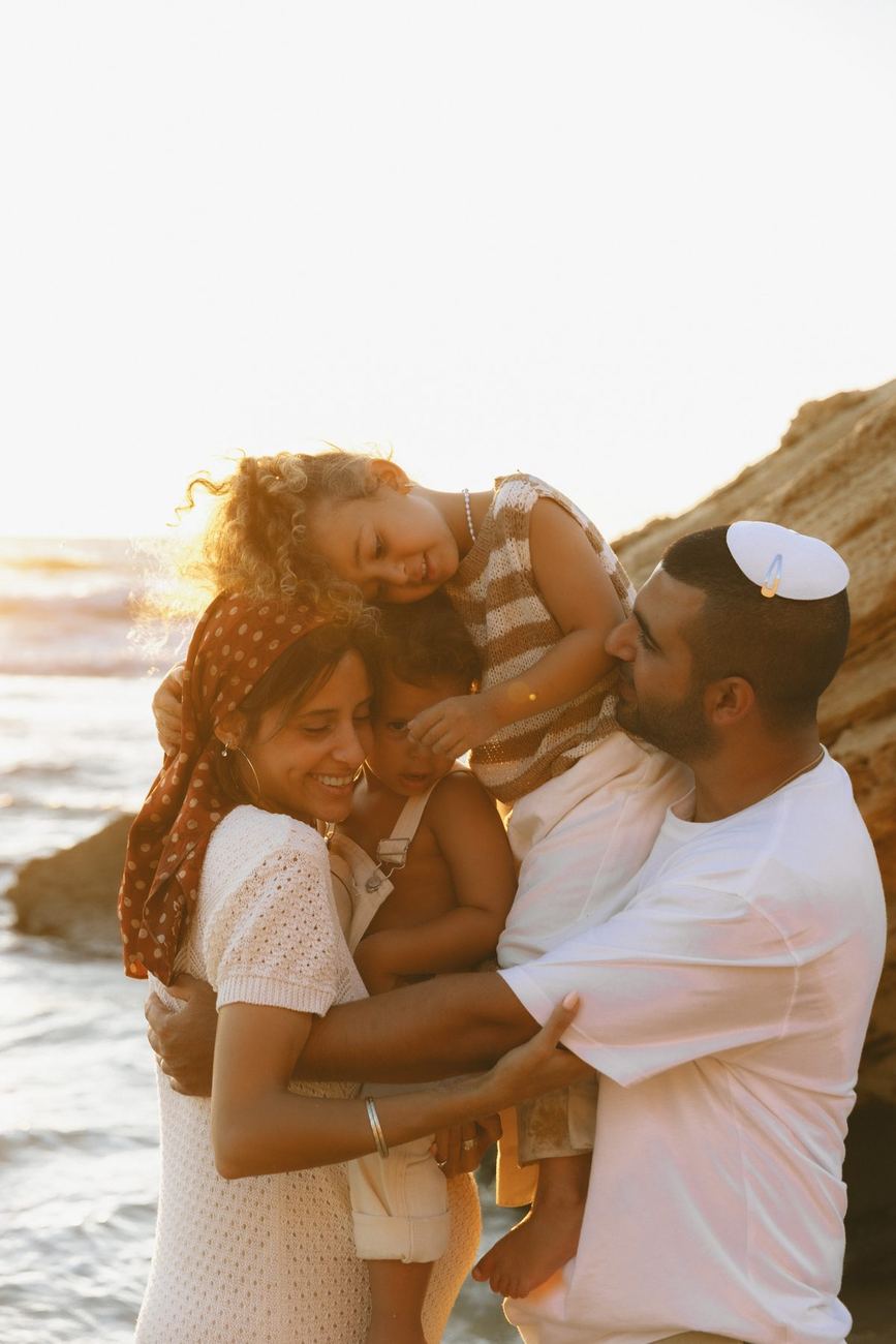 משפחה מתחבקת ליד הים